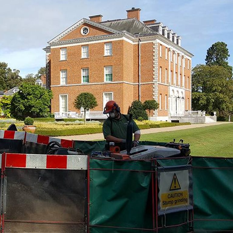 Phil from Green & Co at the grinder, screened off in front of a country house
